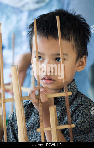 Jakarta, Indonesien. 3. November 2014. Ein ehemaliges Straßenkind spielt mit indonesischen Musikinstrumente in Jakarta, Indonesien, 3. November 2014. Schauspielerin Natalia Woerner unterstützt die Kindernothilfe, eine deutsche Hilfsorganisation für Kinder, welche ein Kinderdorf in Jakarta wo Kinder einfache Aufgaben Services lernen wie das Waschen und kochen. Laut des indonesischen Ministeriums für soziale Angelegenheiten Leben mehr als 11.000 Kinder auf der Straße in Jakarta. Foto: MAURIZIO GAMBARINI/Dpa/Alamy Live News Stockfoto