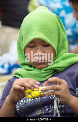 Jakarta, Indonesien. 3. November 2014. Ein ehemaliges Straßenkind näht bei einem Workshop in Jakarta, Indonesien, 3. November 2014. Schauspielerin Natalia Woerner unterstützt die Kindernothilfe, eine deutsche Hilfsorganisation für Kinder, welche ein Kinderdorf in Jakarta wo Kinder einfache Aufgaben Services lernen wie das Waschen und kochen. Laut des indonesischen Ministeriums für soziale Angelegenheiten Leben mehr als 11.000 Kinder auf der Straße in Jakarta. Foto: MAURIZIO GAMBARINI/Dpa/Alamy Live News Stockfoto