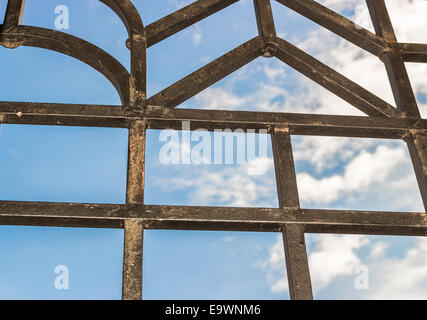 Schwarzes Eisen Gitter am bewölkten Sommerhimmel: gerader Linie bildet Quadrat und Dreieck Formen am bewölkten Himmelshintergrund Stockfoto