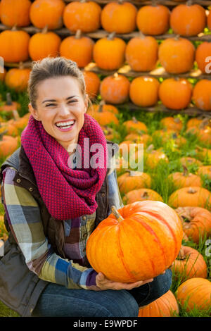 Porträt der glückliche junge Frau mit Kürbis vor Kürbis Zeilen Stockfoto