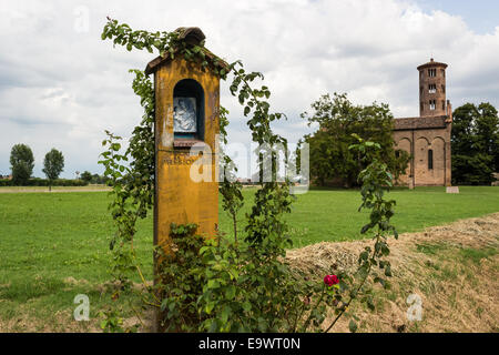 Votiv AEDI-gewidmet der Heiligen Jungfrau Maria in der Nähe der mittelalterlichen Landschaft Kirche Campanile mit romanischen zylindrische Glockenturm, befindet sich in der Ortschaft Santa Maria in Fabriago in der Region Emilia-Romagna in Norditalien Stockfoto