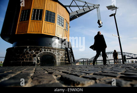 Köln, Deutschland. 28. Oktober 2014. Ein Mann geht vorbei an einer alten Hafenkran, wie er entlang der Böschung am Rheinufer in Köln, 28. Oktober 2014 Spaziergänge. Foto: Oliver Berg/Dpa/Alamy Live News Stockfoto