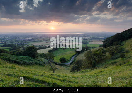 Kurvenreiche Landstraße auf Coaley Gipfel, mit Blick auf die Severn Vale darüber hinaus. Gloucestershire, UK. Stockfoto