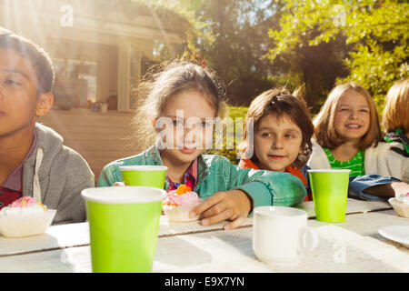 Glückliche Freunde mit bunten Tassen und cupcakes Stockfoto