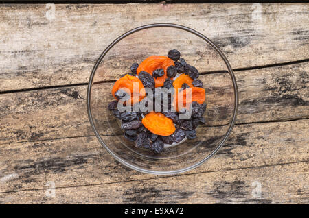 Getrocknete Früchte in Glasschüssel auf hölzernen Hintergrund. Top View-Bild Stockfoto