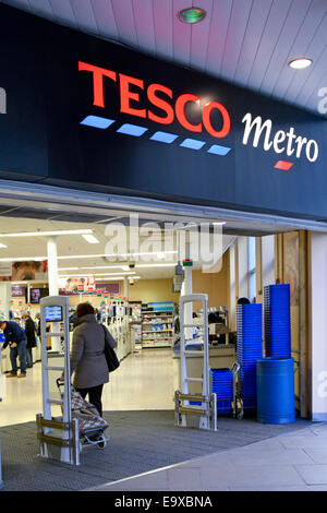 Shopper mit Einkaufswagen Eintritt in Tesco Metro Supermarkt Lebensmittelgeschäft Geschäft in großen geschäftigen Büroviertel City of London England Stockfoto