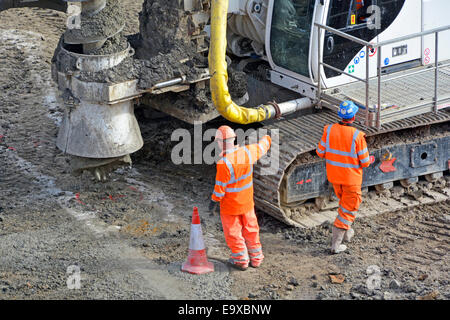 Nahaufnahme von Kegelspuren Nassbeton in fertiggestellten Fundamentstapeln Arbeiter führen die Stapelmaschine zum nächsten Standort auf der Baustelle in Großbritannien Stockfoto