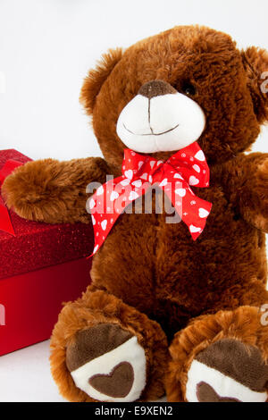 Ein Teddybär, stützte sich auf ein Geschenk-Box. Stockfoto
