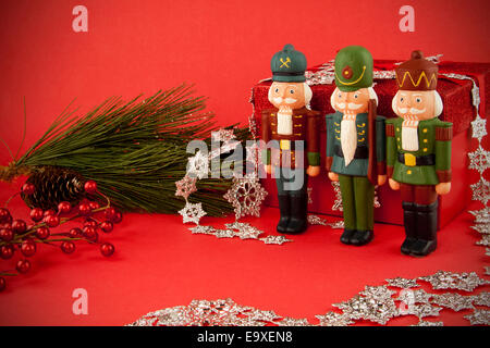Wache stehen drei Nussknacker durch ein Weihnachtsgeschenk. Stockfoto