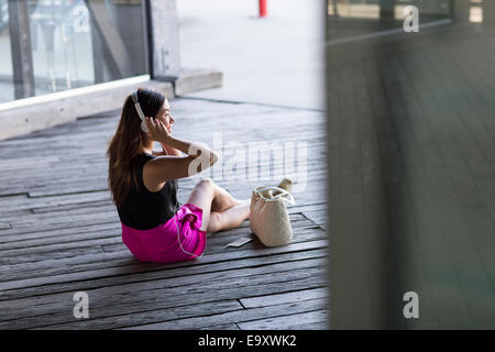 Eine junge Asiatin konsumieren von Inhalten auf ihr Smartphone im freien Stockfoto