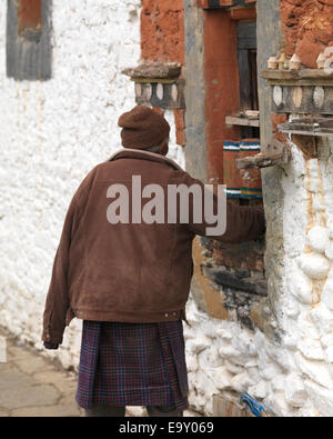 Mann dreht Gebetsmühlen bei Jambay Lhakhang, Chokhor Tal, Bumthang Bezirk, Bhutan Stockfoto