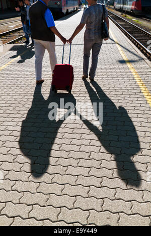 Reifen entscheidend älteres Ehepaar am Bahnhof. Unterwegs im Urlaub Stockfoto