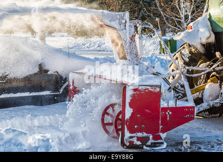 Schneefräse und Traktor eine private Auffahrt ausblasen. Stockfoto