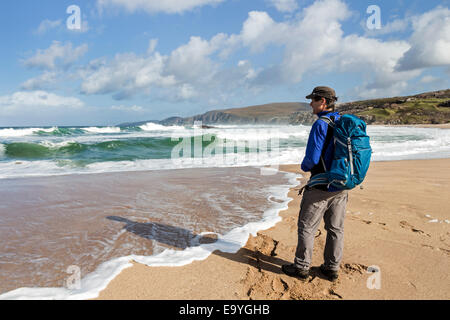 Walker beobachten die Wellen Sandwood Bay, Sutherland Schottland, Vereinigtes Königreich Rollen Stockfoto