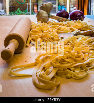 Bandnudeln oder Tagliatelle schneiden bereit, mit Werkzeugen und Gemüse kochen Stockfoto