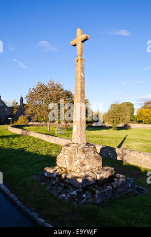 Der letzte Abend Sonnenlicht fällt auf das 14. Jahrhundert Wegkreuz in Cotswold Dorf von Condicote, Gloucestershire Stockfoto