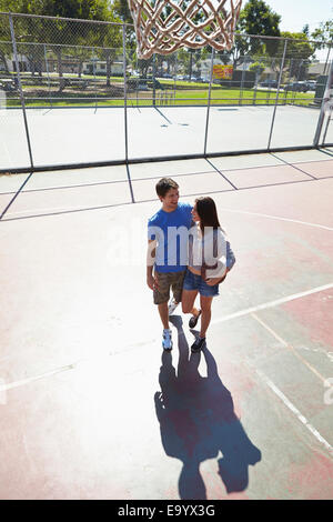 Junges Paar umarmt in Basketballplatz Stockfoto