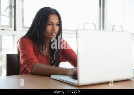 Frau mit Laptop zu Hause Stockfoto