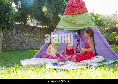 Drei Mädchen spielen mit Pin Räder vor Tipi Stockfoto