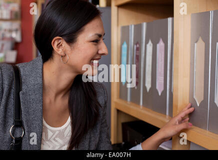 Durchsuchen von Dateien im Schreibwarengeschäft Kundin Stockfoto