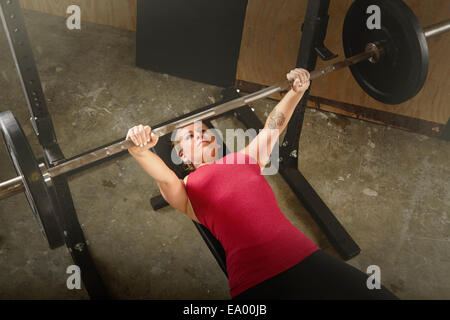 Mitte Erwachsene weibliche Gewichtheber heben Langhantel im Fitness-Studio Stockfoto