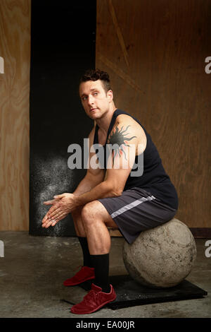 Porträt von Mitte erwachsenen Mann sitzt auf Atlas Ball im Fitness-Studio