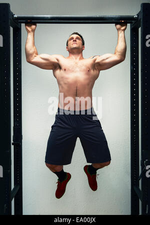 Mitte Männchen tun Pull Ups auf Übung Bar im Fitness-Studio Stockfoto