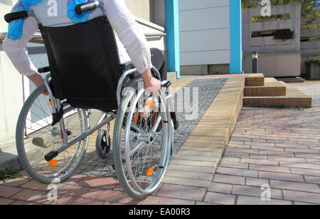 Frau in einem Rollstuhl über eine Rampe Stockfoto