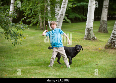 Kleiner Junge im Freien, Stick für den Hund zu werfen Stockfoto
