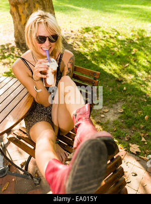 Porträt der jungen Frau im Park Frappe trinken Stockfoto