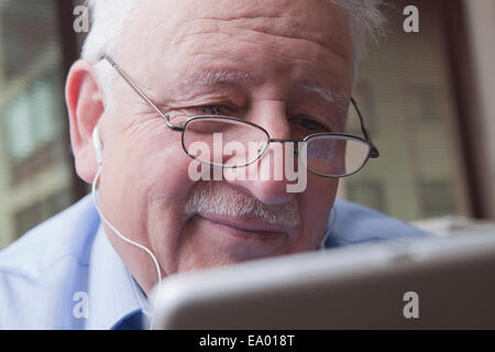 Senior woman lesen digital-Tablette Stockfoto