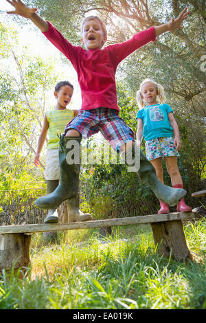 Junge abspringen Gartenbank Stockfoto