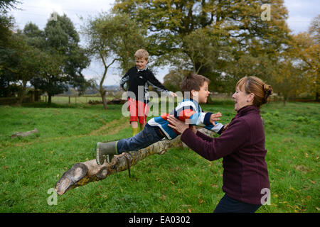 Kind Kinder junge Outdoor-Spaß mit Oma in die Arme springen Vertrauen Vertrauen Uk Modell veröffentlicht Stockfoto