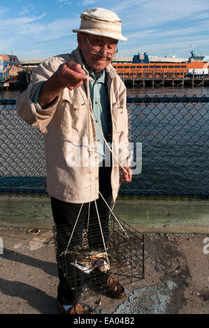 Ein Männer-Fische in die Anlegestelle der Fähre nach Staten Island. Die Staten Island Ferry, die Dichtung die Südspitze von Manhattan ist Staten Stockfoto