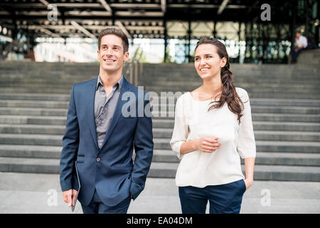 Geschäftsfrau und Mann im Chat beim gehen, London, UK Stockfoto