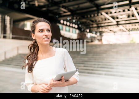 Geschäftsfrau warten außerhalb der Station mit digital-Tablette, London, UK Stockfoto