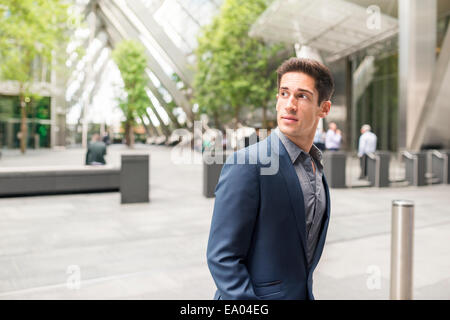 Junge Unternehmer auf der Suche über seine Schulter auf Broadgate Tower, London, UK Stockfoto