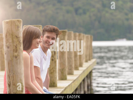 Junges Paar gemeinsam lachen auf Steg über See Stockfoto