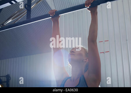 Frau tut Pull ups im Fitness-Studio Stockfoto