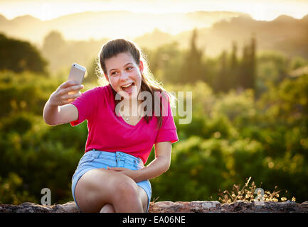 Teenager-Mädchen so dass Gesicht für Selfie auf Smartphone, Mallorca, Spanien Stockfoto