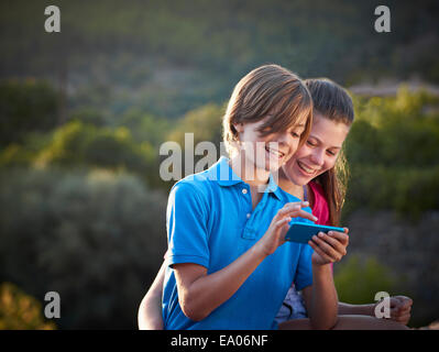 Geschwister Teenager mit Touchscreen auf Smartphone, Mallorca, Spanien Stockfoto