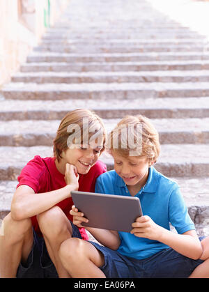 Brüder Blick auf digital-Tablette auf Dorf Schritte, Mallorca, Spanien Stockfoto