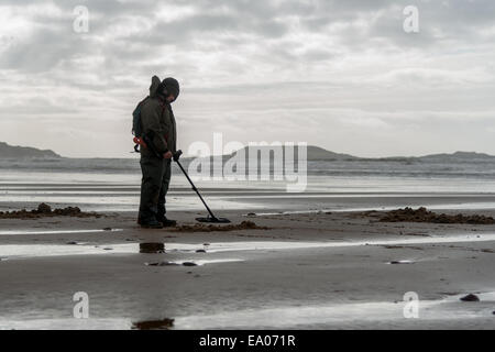 Ein Mann mit Metalldetektor sucht an einem Strand in der Nähe von Llangennith, Gower Halbinsel Süd Walles. UK Stockfoto