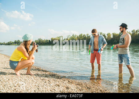 Junge Frau, die Männer von See fotografieren Stockfoto