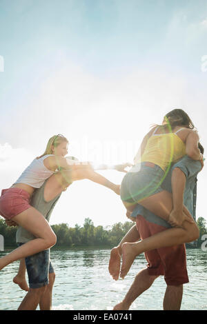 Junge Männer, junge Frauen, die Piggy backs Stockfoto