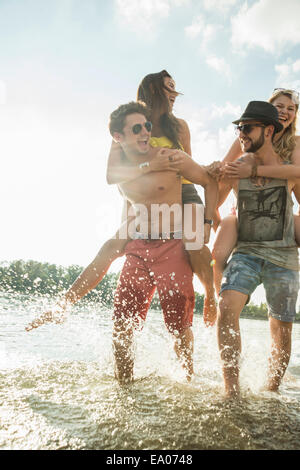 Junge Männer, junge Frauen, die Piggy backs Stockfoto