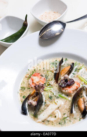 Tintenfisch-Suppe mit Muscheln in einem weißen Teller Stockfoto