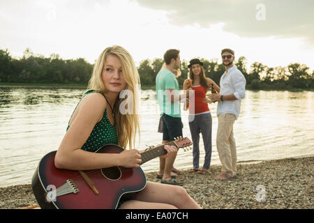 Junge Frau, die Gitarre von See Stockfoto