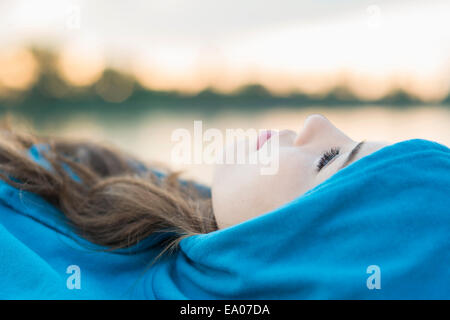 Junge Frau trägt blau mit Kapuze oben liegend Stockfoto