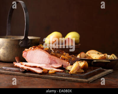 Weihnachtsessen. Geröstete Birnen und Muscavado Zucker geheilt Lende mit Kartoffeln, Äpfeln und Kräutern Stockfoto